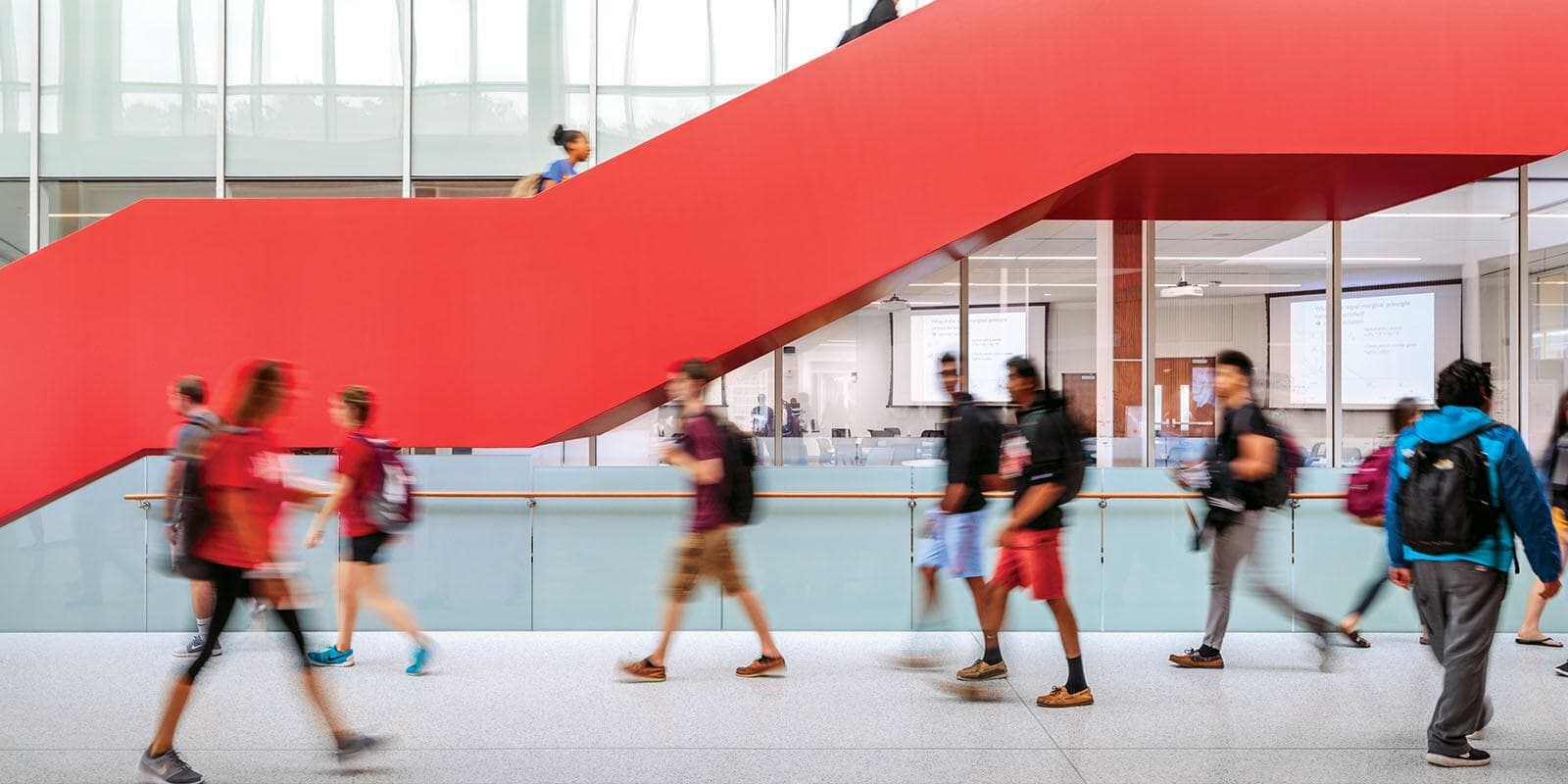 Students walking around a red staircase